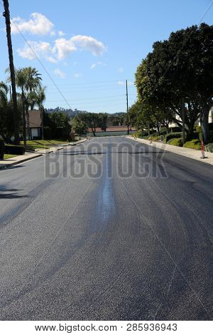 street repair. Fresh slurry or blacktop on surface streets. road work filling pot holes and cracks. fresh oil. 