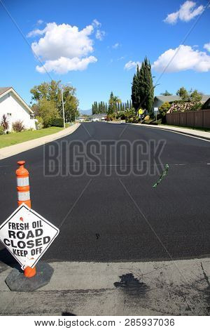 street repair. Fresh slurry or blacktop on surface streets. road work filling pot holes and cracks. fresh oil. 