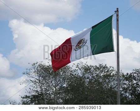 National Maxican Flag At Chichen Itza City Near Interesting Archaeological Site In Mexico With Trees