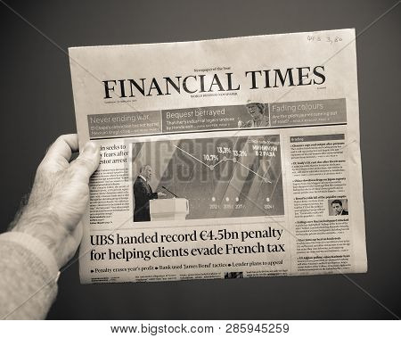 Paris, France - Feb 22, 2019: Man Hand Holding Against Gray Background Financial Times Business News