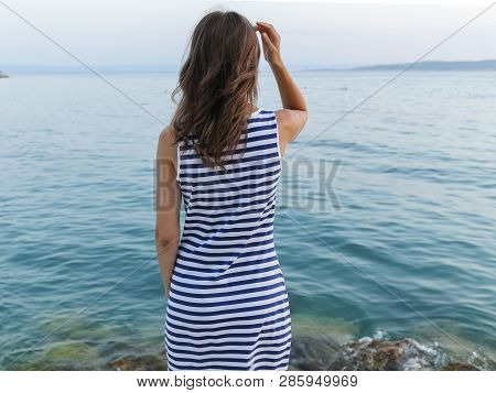 Girl Standing On Shore And Looking At  Sea