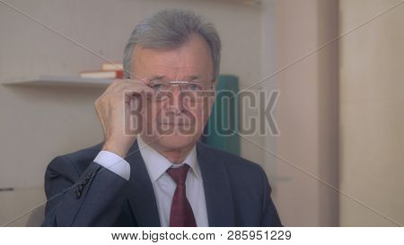 Portrait Elderly Businessman Looking At The Camera. Handsome Grizzled Man Wearing Suit And Necktie.