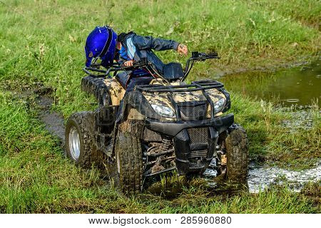 The Boy Is Traveling On An Atv.