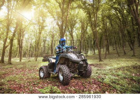The Boy Is Traveling On An Atv.