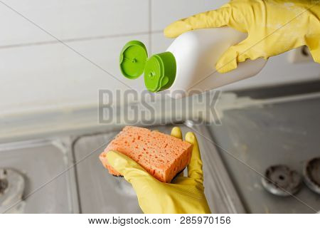 Close-up Of Hands Applying Liquid Soap From Cleanser Bottle To Sponge At Home. Extruding Detergent O