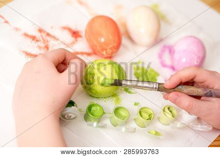 Close Up Of Kid  S Hand Holding An Ester Egg During Painting. Happy Ester Concept