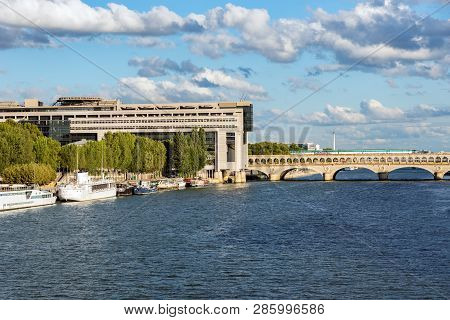 Metro With Tags Crossing Bercy Bridge With French Ministry For The Economy And Finance In Background