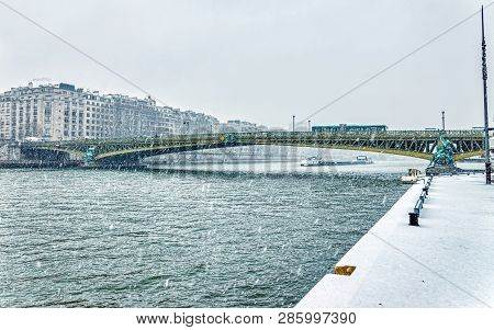Snowfall Over Pont Mirabeau In Winter - Paris France. The Mirabeau Bridge Spans The Seine From The 1