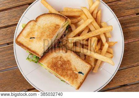 Club Sandwich And French Fries On A Plate Makes A Delicious Meal When Hungry.