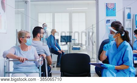 Doctor In Examination Room Listening Senior Patient Lungs With Stethoscope. Medical Staff Visor Agai