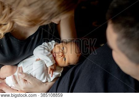 Young Father And Mother Holding Their Newborn Baby Son. Mom, Dad And Baby. Happy Family Concept. Cop
