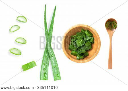 Isolated Of Top View Green Fresh Aloe Vera Leaf Are Sliced In Wooden Bowl And Spoon On White Backgro