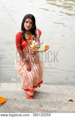 Portrait Of Beautiful Indian Girl Wearing Traditional Indian Saree, Gold Jewellery And Bangles Holdi