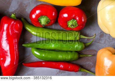 Assortment Of Peppers On The Grey Table. Top View