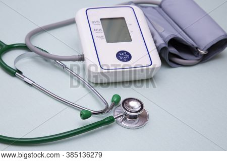 Stethophonendoscope And Blood Pressure Meter On A Green Background.concept Of Medical Services And I