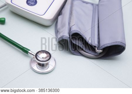 Stethophonendoscope And Blood Pressure Meter On A Green Background.concept Of Medical Services And I