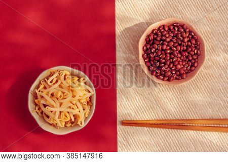 Red Mung Beans And Beansprouts In The Bowls With Chopsticks On White And Red Background. Healthy Eat