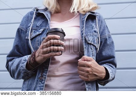 Hippie Woman Wearing Boho Leather Bracelets On A Wrist And Jeans Denim Jacket Holding A Takeaway Pap