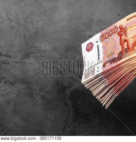 Russian Cash Banknotes Of Five Thousand Rubles, The Bundle Hangs On A Gray Background.