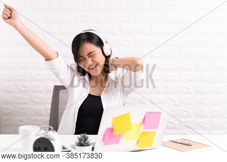 Happy Woman With Headphones Listening Music At Office