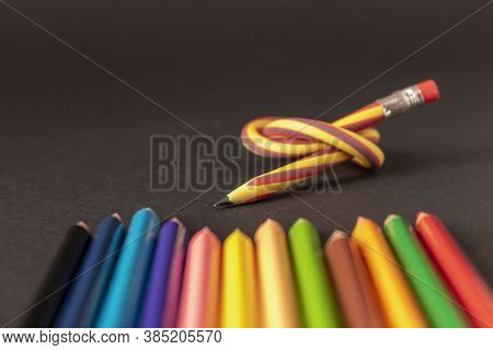 Flexible Pencil And A Set Of Colored Pencils On A Dark Background. Selective Focus