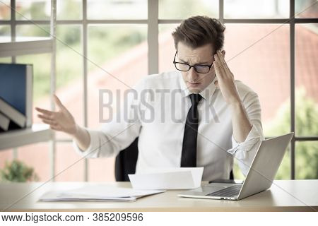 Young Caucasian Businessman Wearing Eyeglasses Feel Shocked And Afraid When Read Letter Of Get Fired