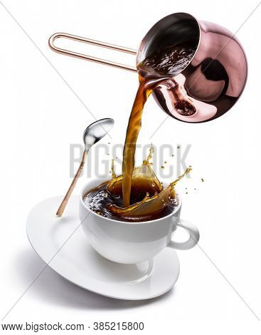 Coffee concept image. Coffee pouring into the cup with splaching from the cooper cezve. Isolated on white background.