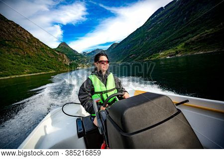 Woman driving a motor boat. Geiranger fjord, Beautiful Nature Norway.Summer vacation.
