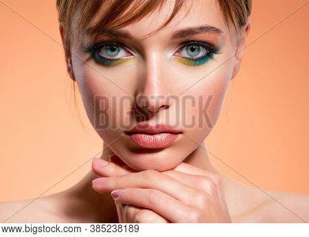 Beautiful girl with trandy makeup. Face of an young girl close-up with a green color makeup. Stylish makeup.