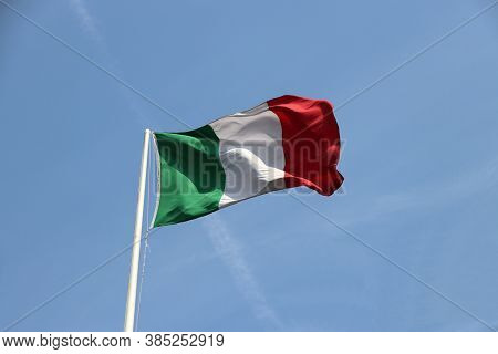 Tri Color Of Italian Flag, Green White And Red Color With On Blue Sky Background. Blown Away By Wind