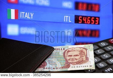 One Thousand Lire Of Italy Banknote With Black Wallet On The Calculator With Digital Board Of Curren
