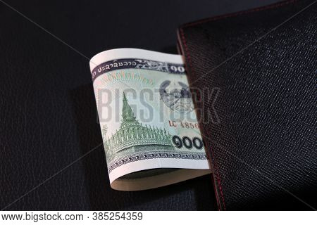 One Thousand Of Banknote Currency Lao Kip With Black Wallet On The Black Floor, It Is The Money Of L