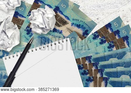 5 Canadian Dollars Bills And Balls Of Crumpled Paper With Blank Notepad. Bad Ideas Or Less Of Inspir