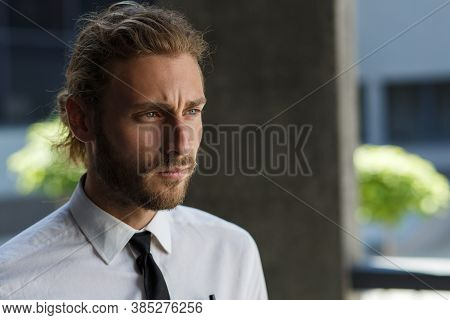 Portrait Of A Handsome Curly-haired Man, In A Business Style. The Astute Look Of An Attractive Busin