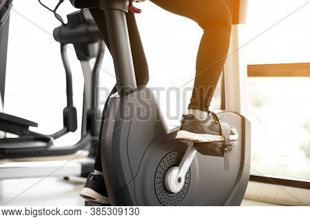 Close Up Foot Biking In Gym, Exercising Legs Doing Cardio Workout Cycling Bikes.