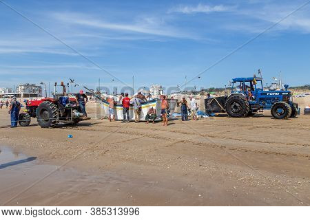 Costa Da Caparica, Portugal - September 10, 2020: An Artel Of Fishermen Trawls Fish From The Tourist