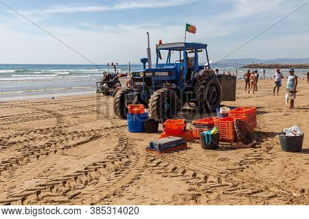 Costa Da Caparica, Portugal - September 10, 2020: An Artel Of Fishermen Trawls Fish From The Tourist