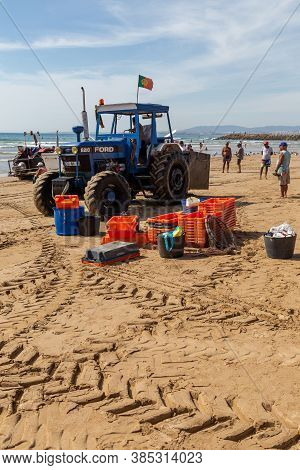 Costa Da Caparica, Portugal - September 10, 2020: An Artel Of Fishermen Trawls Fish From The Tourist