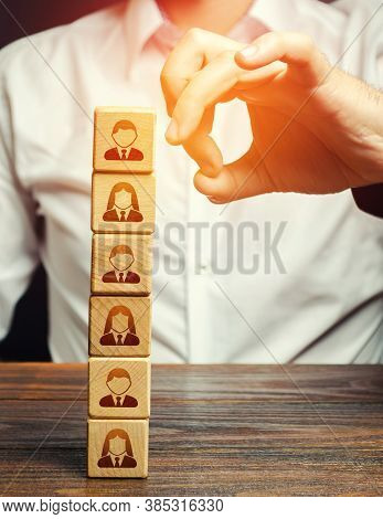 Man Knocks Down A Tower Of Blocks With Employees. Mass Layoffs, Closing A Business Company. Dismissa