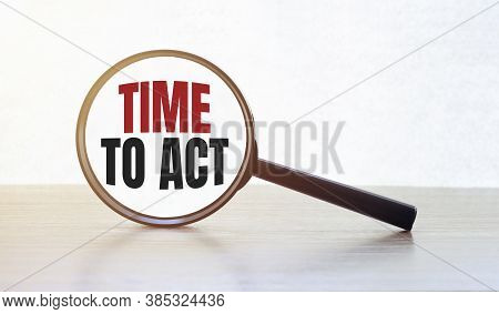 Magnifying Glass With Text Time To Act On Wooden Table.