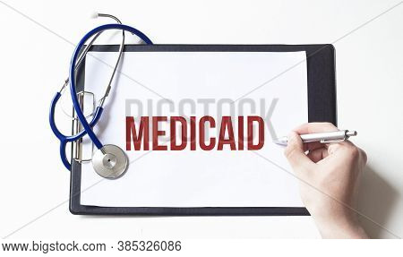 Doctor Holding A Paper Plate With Text Medicaid, Medical Concept