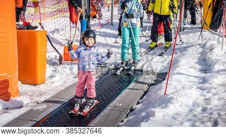 Young, Happy Skier Girl Going Up On Conveyor Lift Belt To Green Ski Zone For Ski Lessons, Bialka Tat