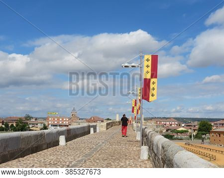 Medieval Bridge Over Orbigo River In Hospital De Orbigo, Leon, Spain, Decorated With Ancient Flags F