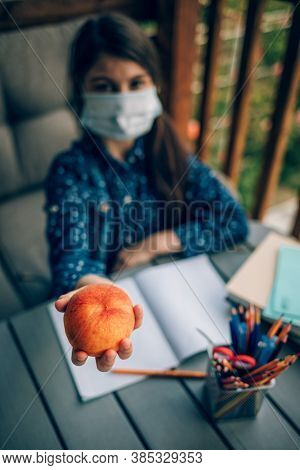 Healthy School Breakfast, Peach In The Hands Of A Schoolgirl. Snack During Homework