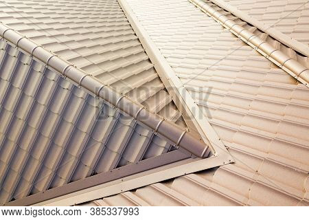 Aerial View Of House Roof Structure Covered With Brown Metal Tile Sheets.