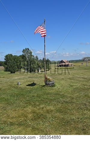 De Smet, South Dakota, August 5, 2020: The Usa Flag And Distance Building Are Building Are Found On 