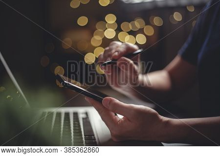 Close Up Shot Of Hands Using Smart Pen Typing On Smart Phone For Searching With Laptop On Glow Bokeh
