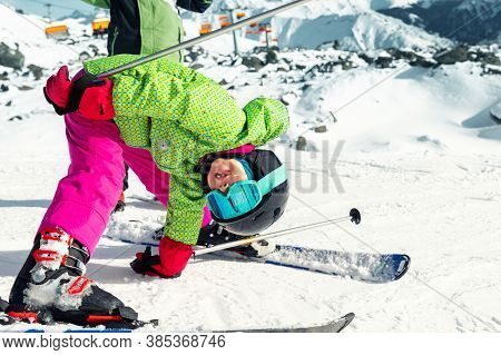 Active Adorable Preschooler Caucasian Kid Girl Portrait With Ski In Helmet, Goggles And Bright Suit 