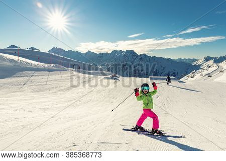 Active Adorable Preschooler Caucasian Kid Girl Portrait With Ski In Helmet, Goggles And Bright Suit 