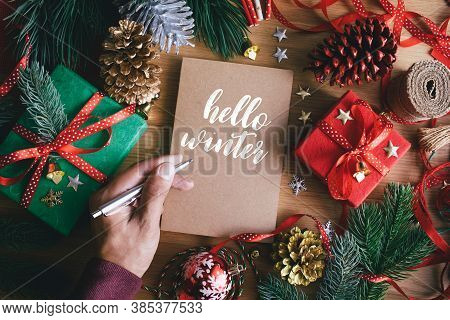 Hello Winter With Human Hand Writing Greeting Cards With Gift Box Present And Ornament Element